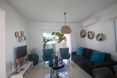 a living room with a black couch and blue chairs at Romeo & Juliet in Protaras