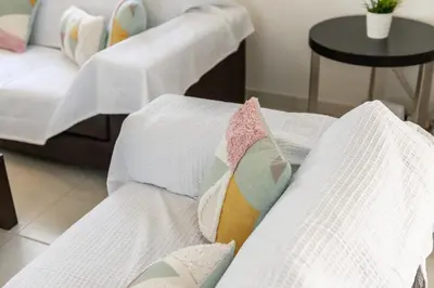 a row of beds with white sheets and pillows at Protaras Villa Dafni in Protaras
