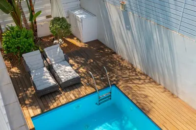 a deck with a swimming pool and two chairs at Protaras Villa Dafni in Protaras