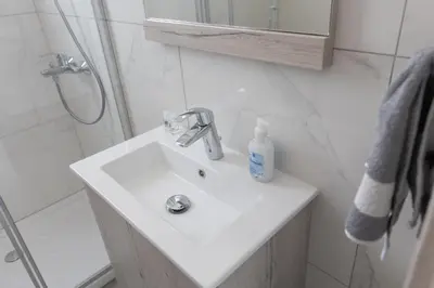 a bathroom with a white sink and a shower at Sol E Mar Villas ( Gold Emerging Villas ) in Protaras