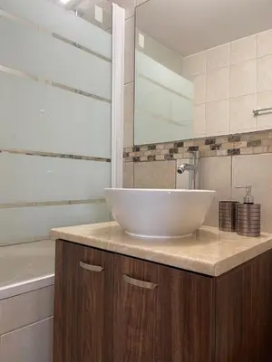 a bathroom with a white sink and a bath tub at Cielo Apartment in Ayia Napa