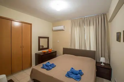 a bedroom with a bed with blue towels on it at Merab Holidays Apartment Castalia 62 in Ayia Napa