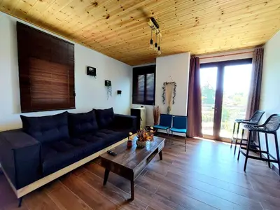 a living room with a black couch and a table at Agros Green Valley Suites in Limassol