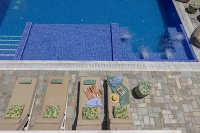 an overhead view of a pool with a table and chairs at Villa Green Haven 2 Protaras Cyprus in Protaras