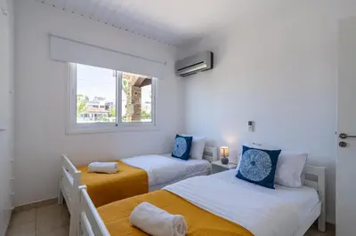 two beds in a room with a window at Keylana's 2-BR Apt in Pyla in Pyla
