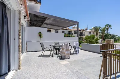 a patio with a table and chairs on a balcony at Keylana's 2-BR Apt in Pyla in Pyla