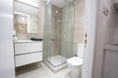 a bathroom with a shower and a toilet and a sink at Eidyllio Luxury Suites Omodos in Omodos