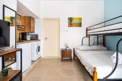 a bedroom with a bunk bed and a kitchen at Zulu Studio in Larnaca w/ Terrace in Larnaka