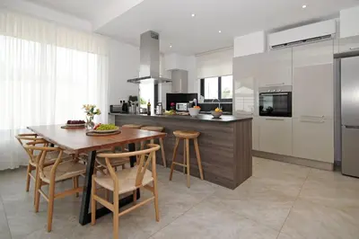 a kitchen with a wooden table and chairs and a counter at Villa Queen Valentina in Protaras