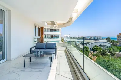 a balcony with a blue couch and a coffee table at Oyster 1-BR Apt in Larnaca in Larnaka