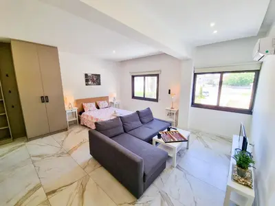 a living room with a couch and a bed at Happy Homes Paradise in Larnaka