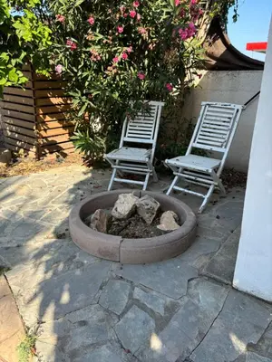 two chairs and a fire pit next to two chairs at Mediterranean poolside garden cottage in Kiti