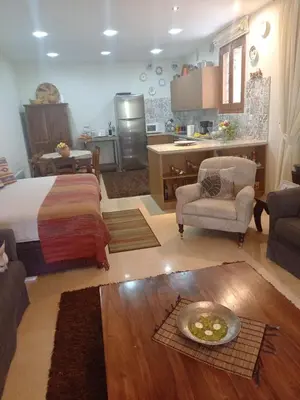 a bedroom with a bed and a living room at Glykoharama Cottage in Kalopanayiotis