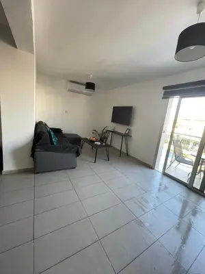 a living room with a couch and a tv at Cielo Apartment No2 in Ayia Napa