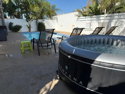 a large pool with chairs and a hot tub at Villa Mario - 2min walk from Kapparis Beach in Paralimni
