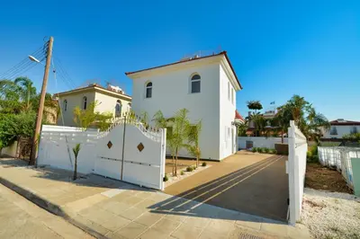a white house with a white fence in front of it at Villa Mario - 2min walk from Kapparis Beach in Paralimni