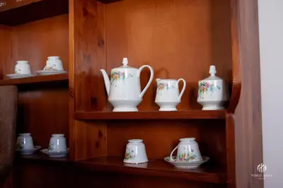 a shelf filled with white vases and saucers at VINGT-DEUX Vouni 22 in Vouni