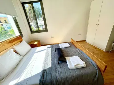a bedroom with a large bed with two towels on it at Demetra 1 Bdr Down Town Nicosia in Nicosia
