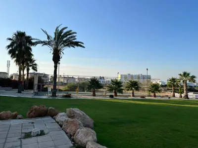 a park with palm trees and rocks in the grass at Lovely cozy one bedroom suite with pool in Protaras