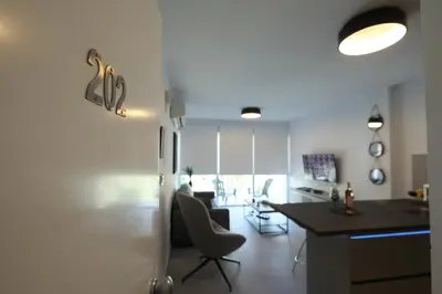 a kitchen and living room with a table and chairs at Lovely cozy one bedroom suite with pool in Protaras