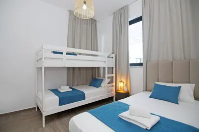 a bedroom with two beds and a bunk bed at Villa Queen Isabella in Protaras