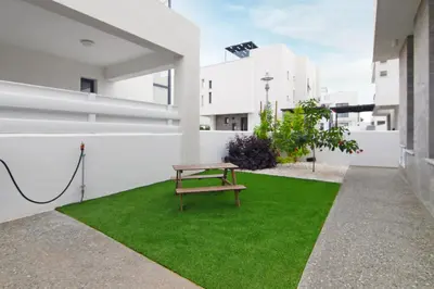 a picnic table on the grass in the courtyard of a building at Villa Queen Isabella in Protaras