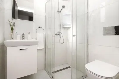 a white bathroom with a shower and a toilet at Villa Queen Isabella in Protaras