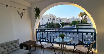 a balcony with a table and chairs and a window at Sherpa Apartments in Ayia Napa