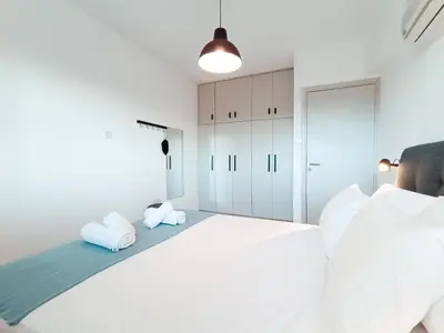 a white bedroom with two white pillows on a bed at The Chalk in Larnaka
