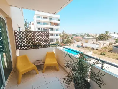 a balcony with two yellow chairs and a swimming pool at The Chalk in Larnaka