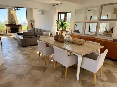 a kitchen and living room with a wooden table and chairs at Villa Grand Zeus in Anoyira