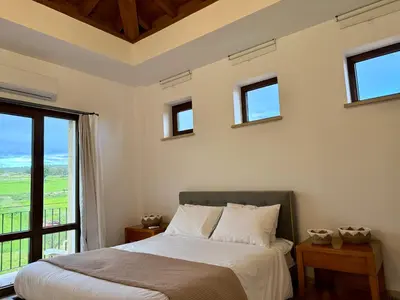 a bedroom with a bed and a large window at Villa Grand Zeus in Anoyira