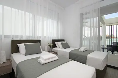 two beds in a room with white and gray at Villa Queen Eleanor in Protaras
