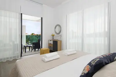 a white bedroom with a bed with two white towels at Villa Queen Eleanor in Protaras