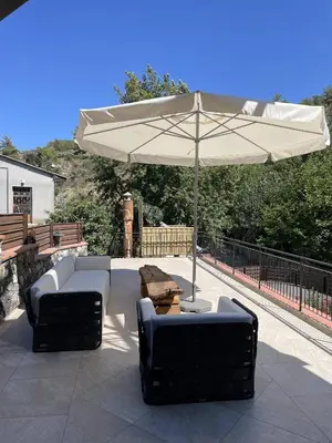 a patio with an umbrella and two chairs and a table at Stone built country house in Louvaras Village in Louvaras