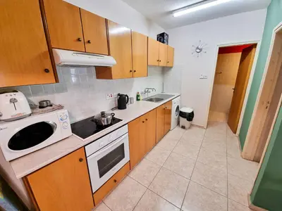 a kitchen with wooden cabinets and a white microwave at Dock Holiday Apartment in Larnaka