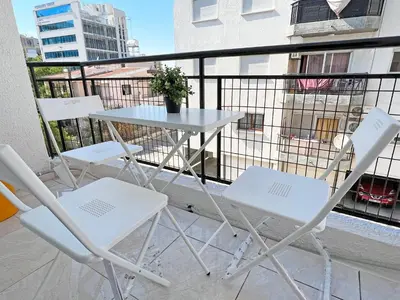 two chairs and a table on a balcony at Albert's apartment Marina 15 in Larnaka