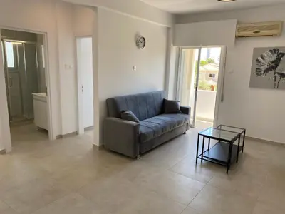 a living room with a couch and a glass table at 1-bedroom apartment with view in Limassol