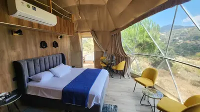 a bedroom with a bed and a large window at Agros Glamping Boutique in Agros
