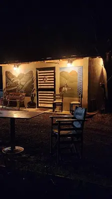 a table and chairs in front of a building at night at Agros Glamping Boutique in Agros