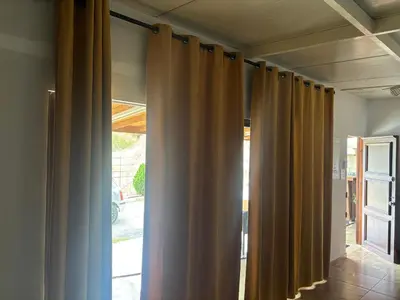 a row of curtains in a room with a window at Sofros To Apomero in Ayios Pavlos