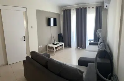 a living room with a couch and a table at Ptolemaidos cosy Family apartment in Larnaka