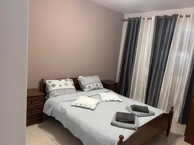 a bedroom with a bed with white sheets and pillows at Ptolemaidos cosy Family apartment in Larnaka