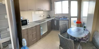 a small kitchen with a table and a table and chairs at Ptolemaidos cosy Family apartment in Larnaka
