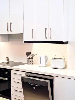 a kitchen counter with white cabinets and a toaster at Sveltos Residence Suites in Larnaka