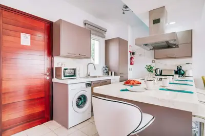 a kitchen with a sink and a washing machine at Villa Pant Poly in Protaras