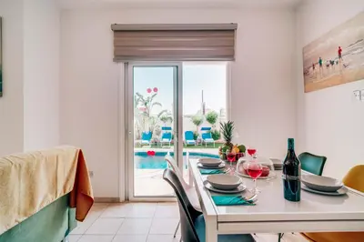 a dining room with a table with wine glasses at Villa Pant Poly in Protaras