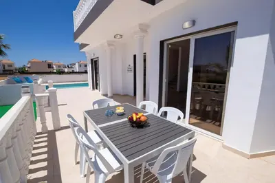 a black table and white chairs on a patio at Villa suncity Boutique Beachfront in Ayia Napa