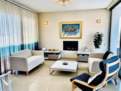 a living room with white furniture and a tv at The Penthouse 401 in Larnaka