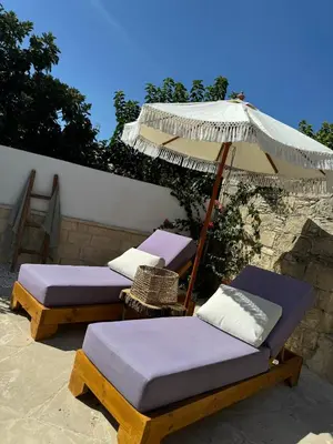 two beds and an umbrella on a patio at Fig&Olive Luxury one bedroom boutique in Pachna in Limassol